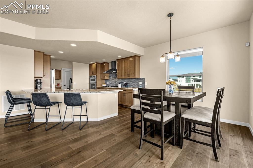 Image 18 of 46: Dining area featuring dark wood-style floors and recessed lighting