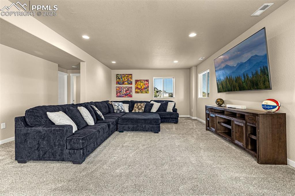 Image 33 of 46: Living area featuring light carpet, recessed lighting, and a textured ceili