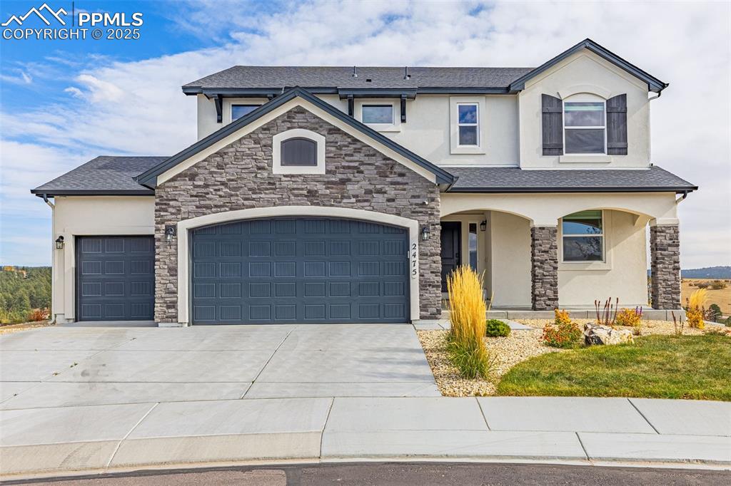 Image 39 of 46: View of front of house with stucco siding, a porch, stone siding, and concr