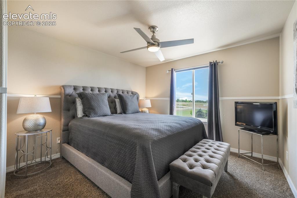 Image 21 of 50: Upper Level Bedroom with Ceiling Fan and Walk-in Closet