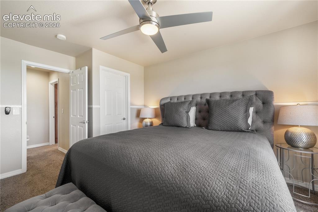 Image 22 of 50: Upper Level Bedroom with Ceiling Fan and Walk-in Closet