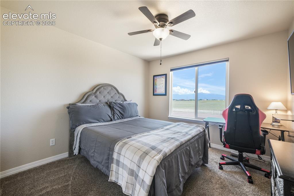 Image 31 of 50: Upper Level Bedroom with Ceiling Fan and View.