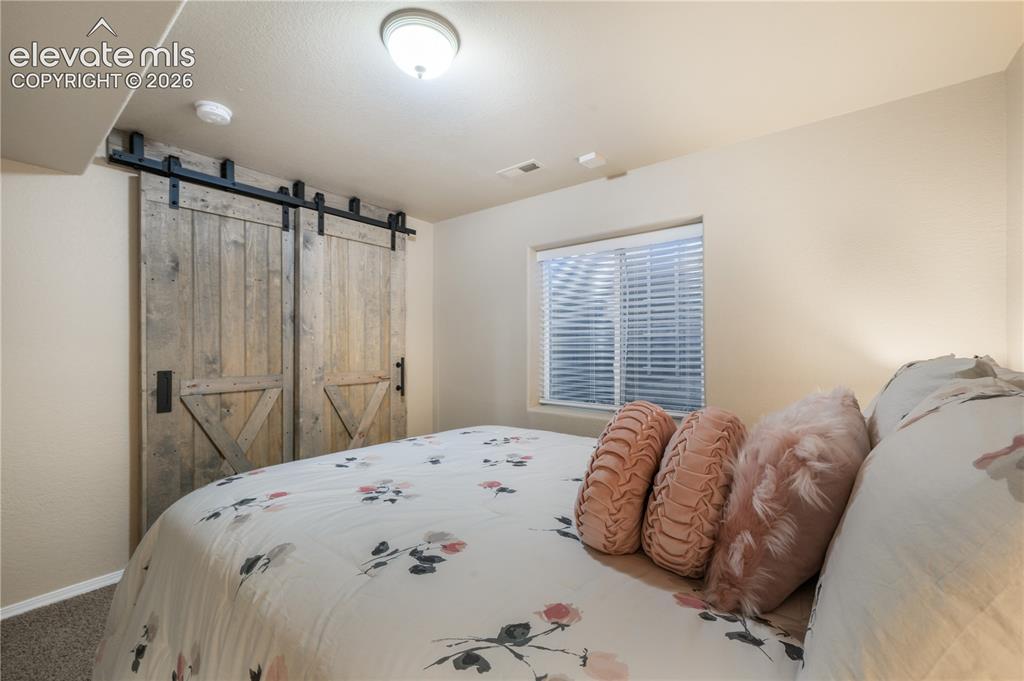 Image 39 of 50: Basement Bedroom with Barn Door connecting to Second Basement Bedroom