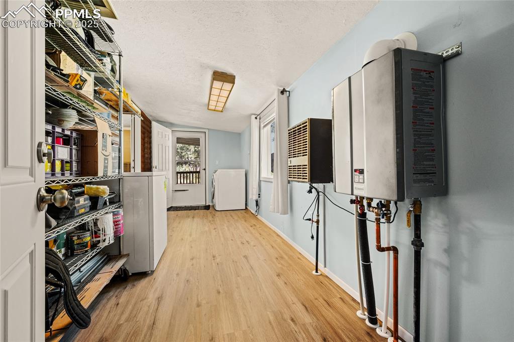 Image 14 of 27: Hallway with wood finished floors and a textured ceiling