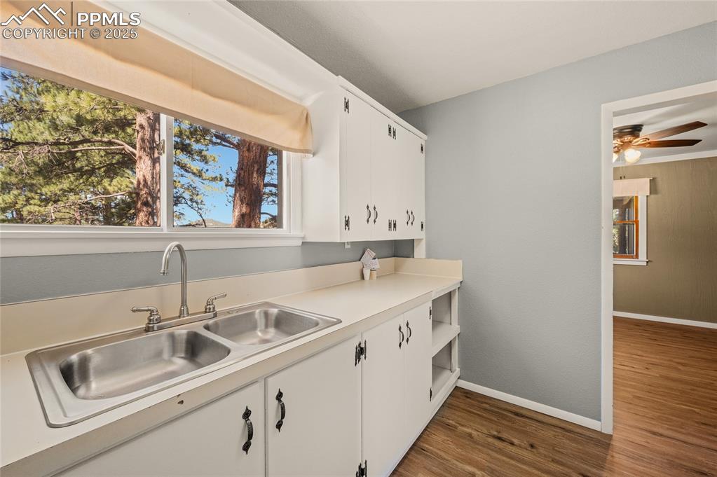 Image 21 of 27: Kitchen featuring dark wood-style floors, ceiling fan, white cabinets, and