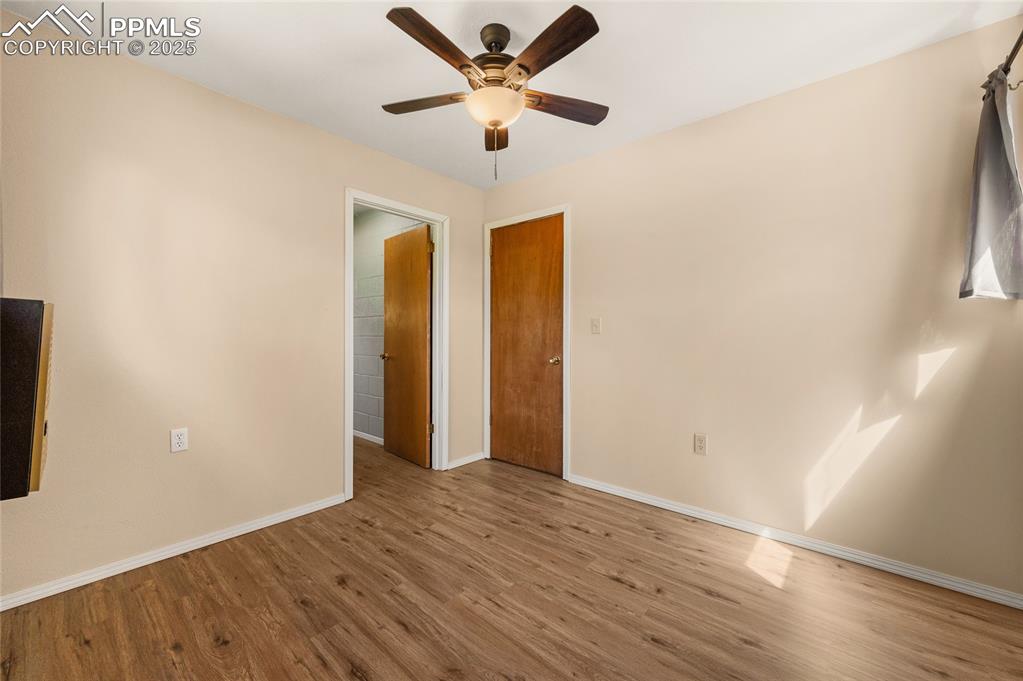 Image 23 of 27: Empty room with wood finished floors and ceiling fan