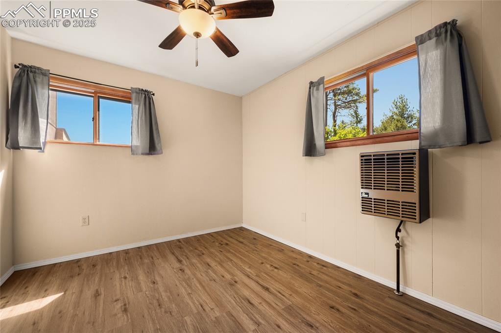 Image 24 of 27: Spare room featuring wood finished floors and ceiling fan