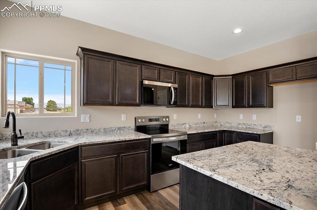 Image 17 of 45: Kitchen with appliances with stainless steel finishes, light wood finished 