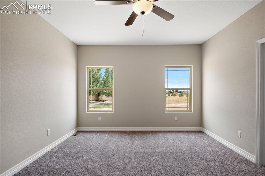 Image 23 of 45: Carpeted spare room featuring a ceiling fan and a textured wall
