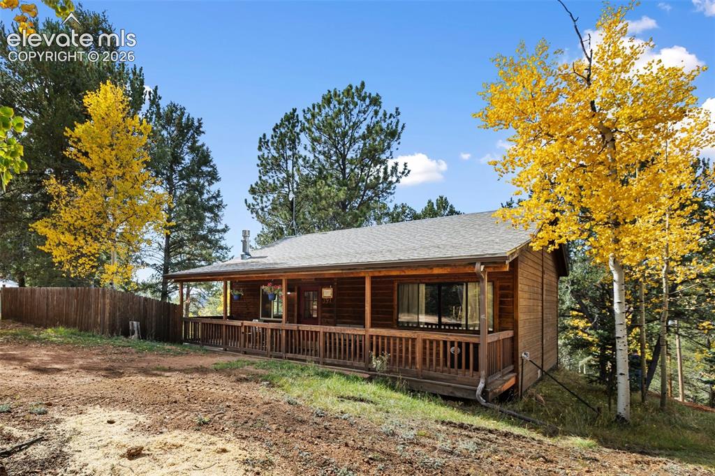 Image 1 of 36: Log siding exterior with an extensive covered front porch