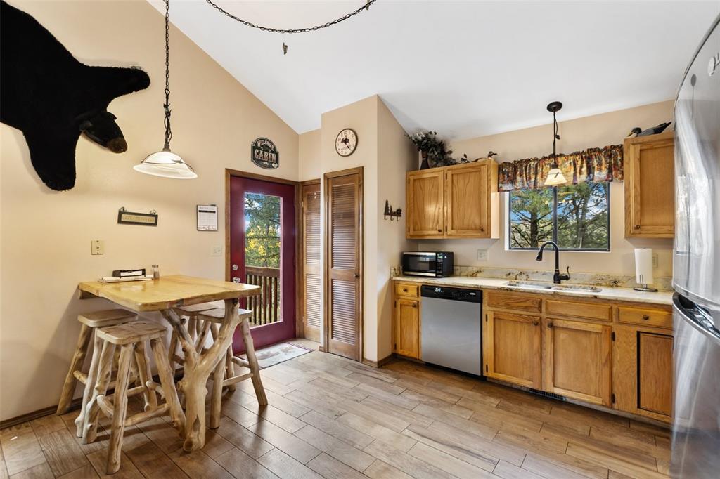 Image 14 of 36: Vaulted ceiling, wood-finish flooring, natural wood cabinetry, stainless st