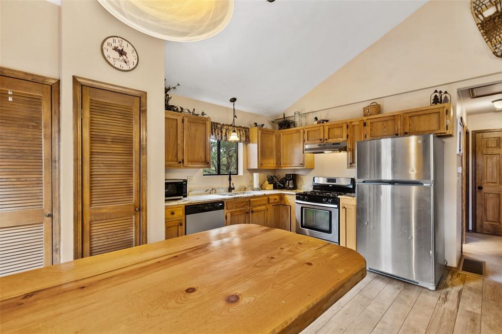 Image 16 of 36: Kitchen featuring light wood cabinetry, stainless steel appliances, and a w