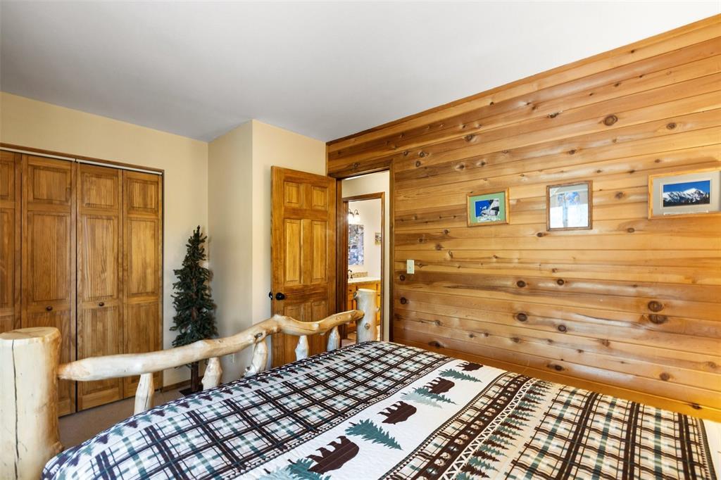 Image 20 of 36: Wood-paneled accent wall, wood-finish bi-fold closet doors, and a wood-fini
