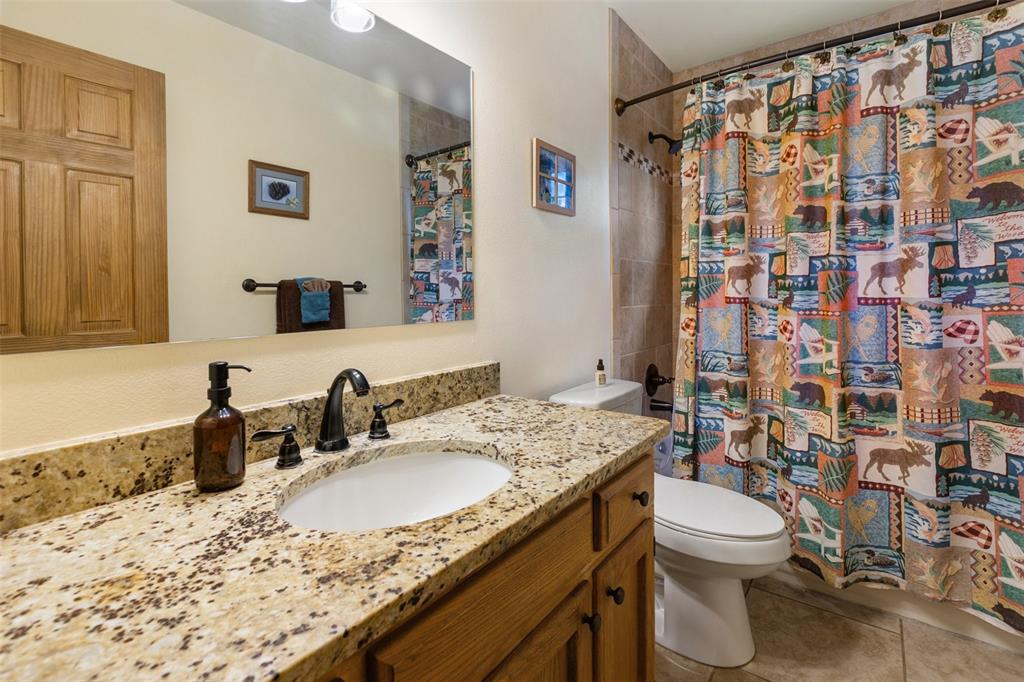 Image 25 of 36: Vanity with a granite countertop, undermount sink, and dark bronze faucet f