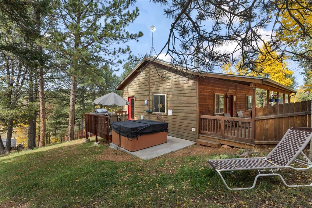 Image 31 of 36: Wood-sided exterior with a sloped roofline, featuring a covered deck and an