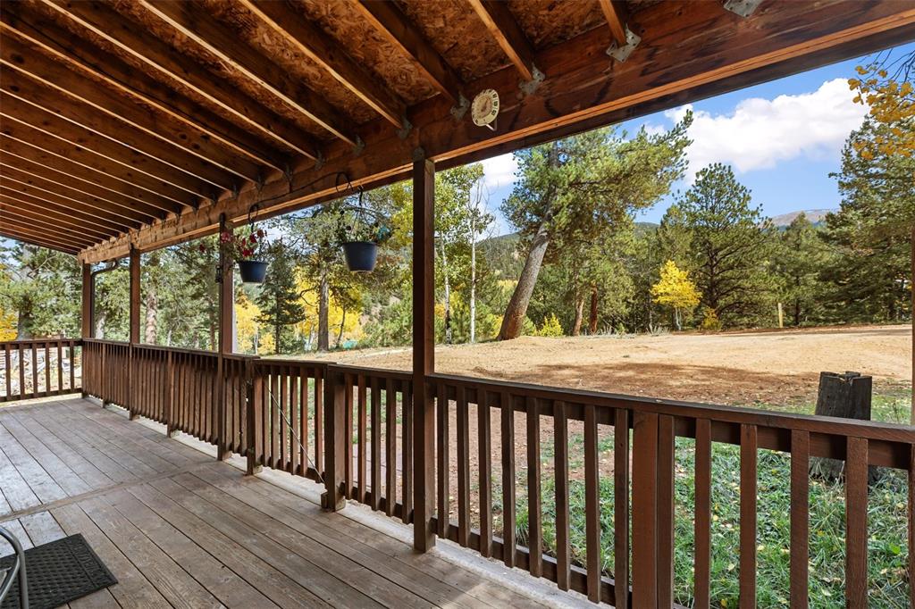 Image 32 of 36: Expansive outdoor deck featuring wood flooring, wood railing, and a wood sl