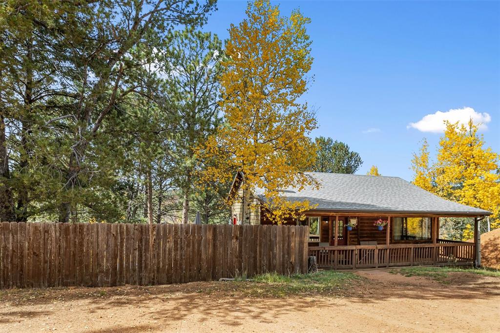 Image 35 of 36: Wood siding with a covered front porch featuring a wood railing