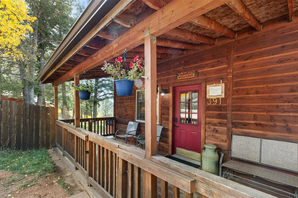 Image 36 of 36: Wood-sided exterior featuring an expansive covered porch with wood railing 