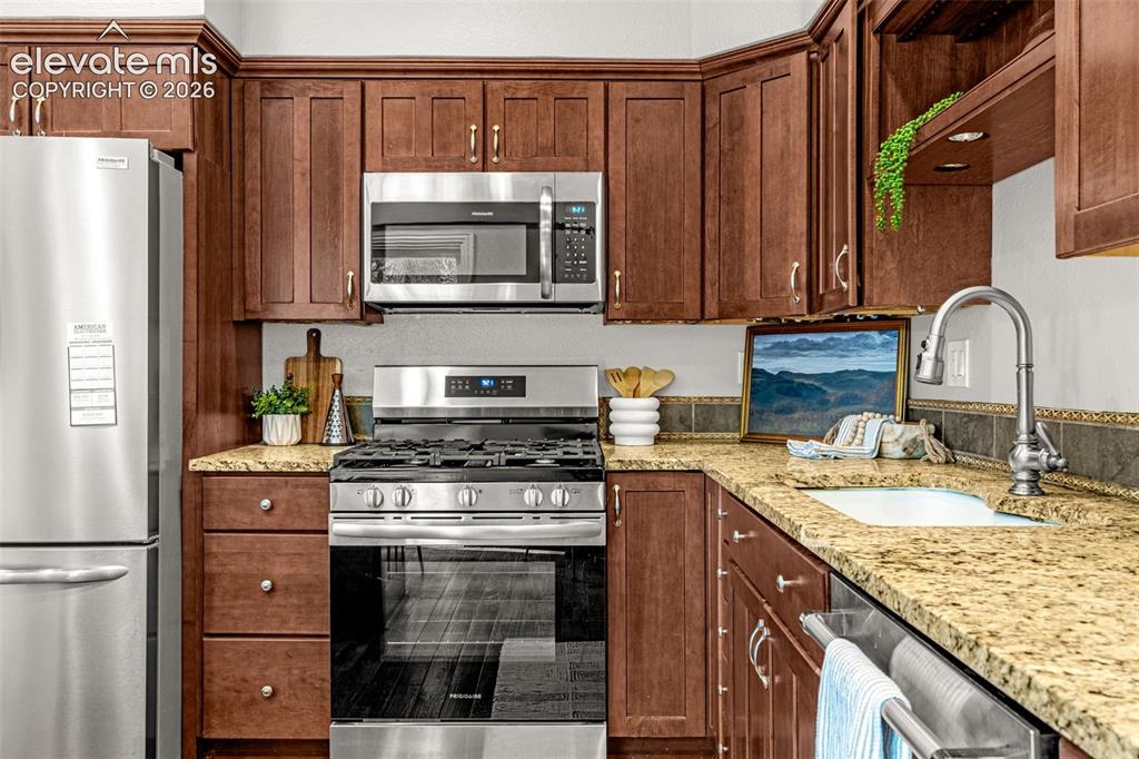 Image 10 of 40: Kitchen featuring hardwood flooring, recessed lighting, and a stainless ste