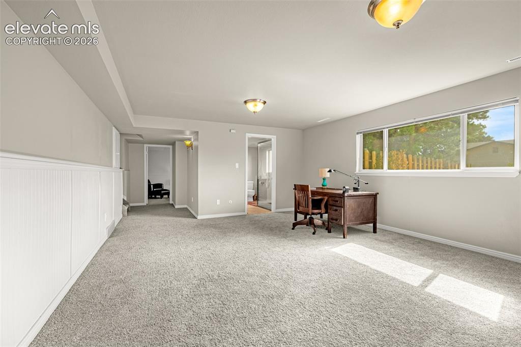 Image 12 of 40: Spacious family room featuring a brick wood-burning fireplace, light gray c