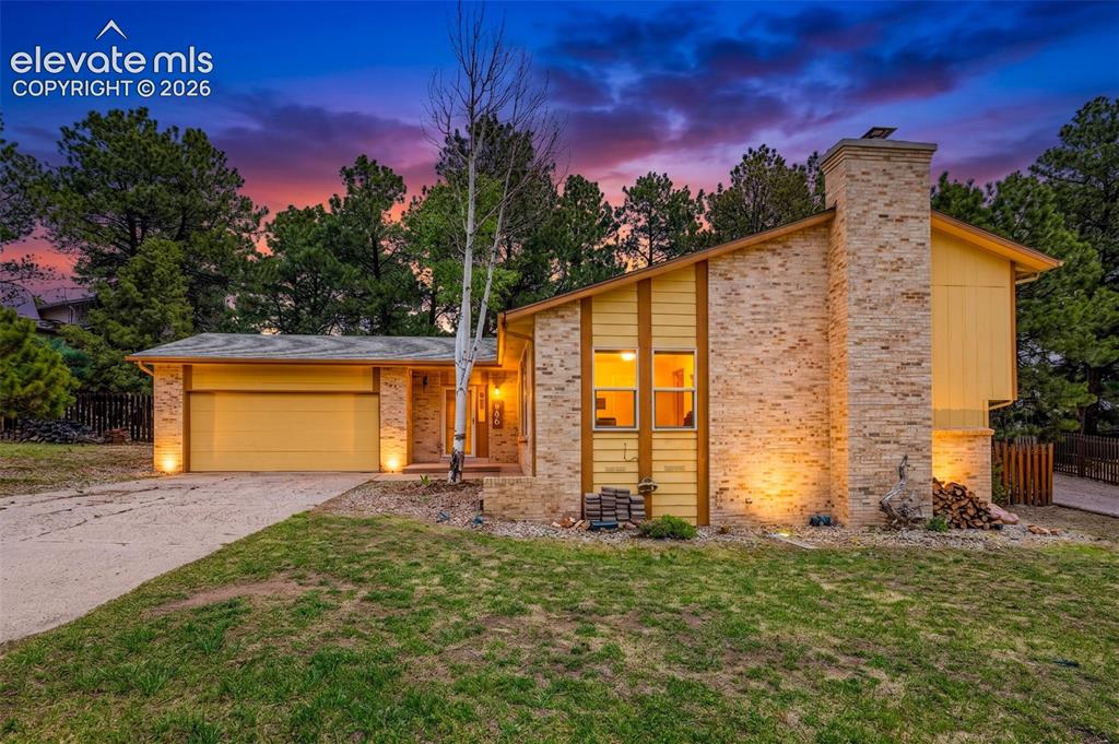 Image 2 of 40: Yellow exterior featuring brick and vertical wood siding