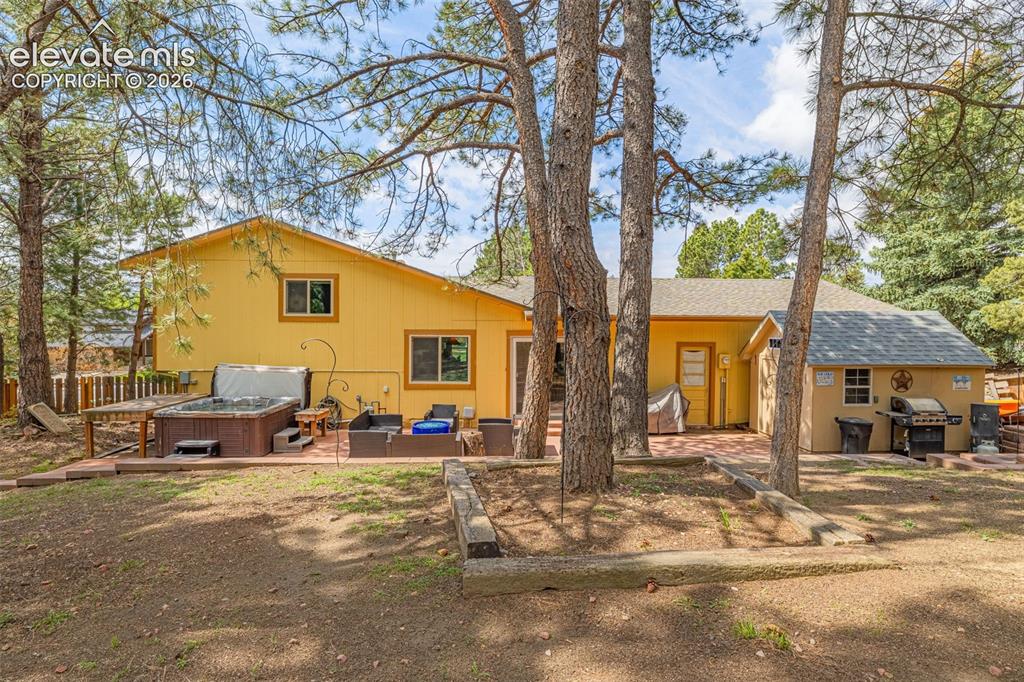 Image 28 of 40: Expansive rear patio featuring a hot tub, and a detached storage shed