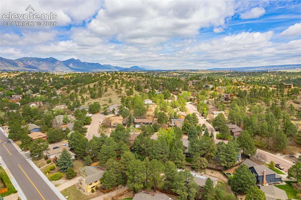 Image 35 of 40: Expansive aerial perspective showcasing mountainous terrain and a residenti