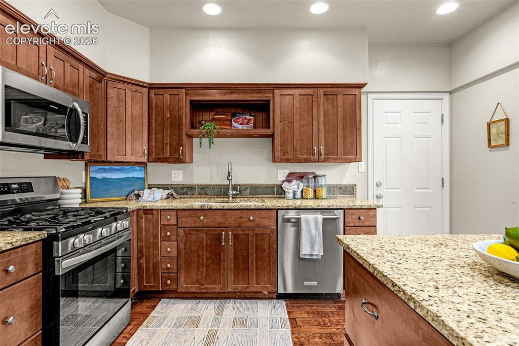 Image 4 of 40: Kitchen featuring a central island with granite countertop, stainless steel