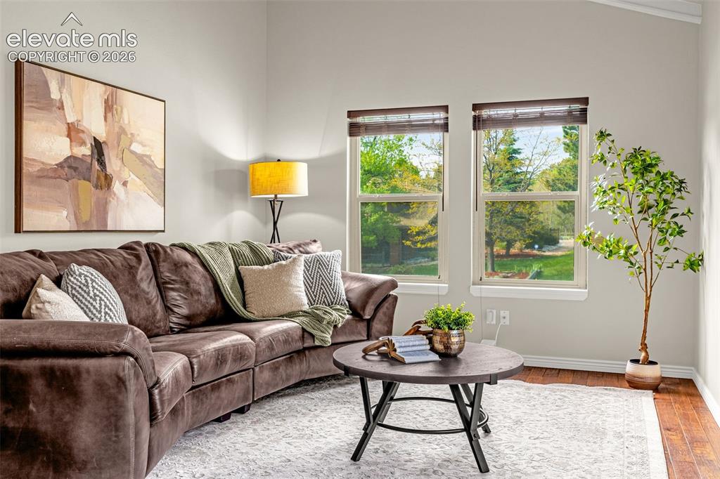 Image 6 of 40: Spacious interior featuring rich hardwood flooring, a carpeted staircase wi