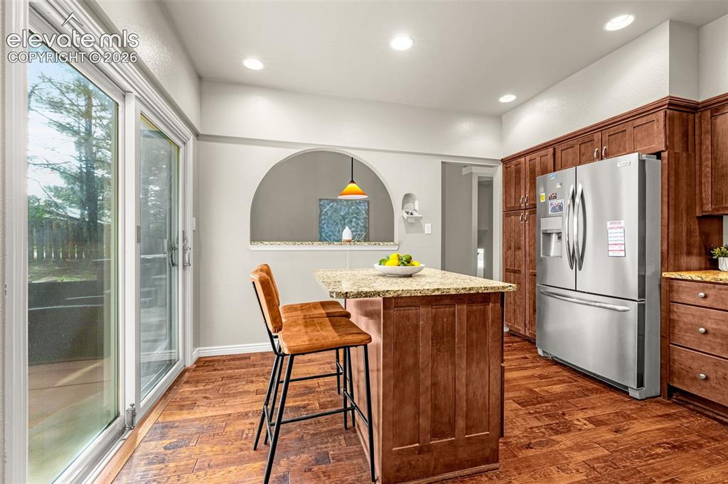 Image 9 of 40: Vaulted ceiling dining room featuring hardwood flooring, a window, a pass-t