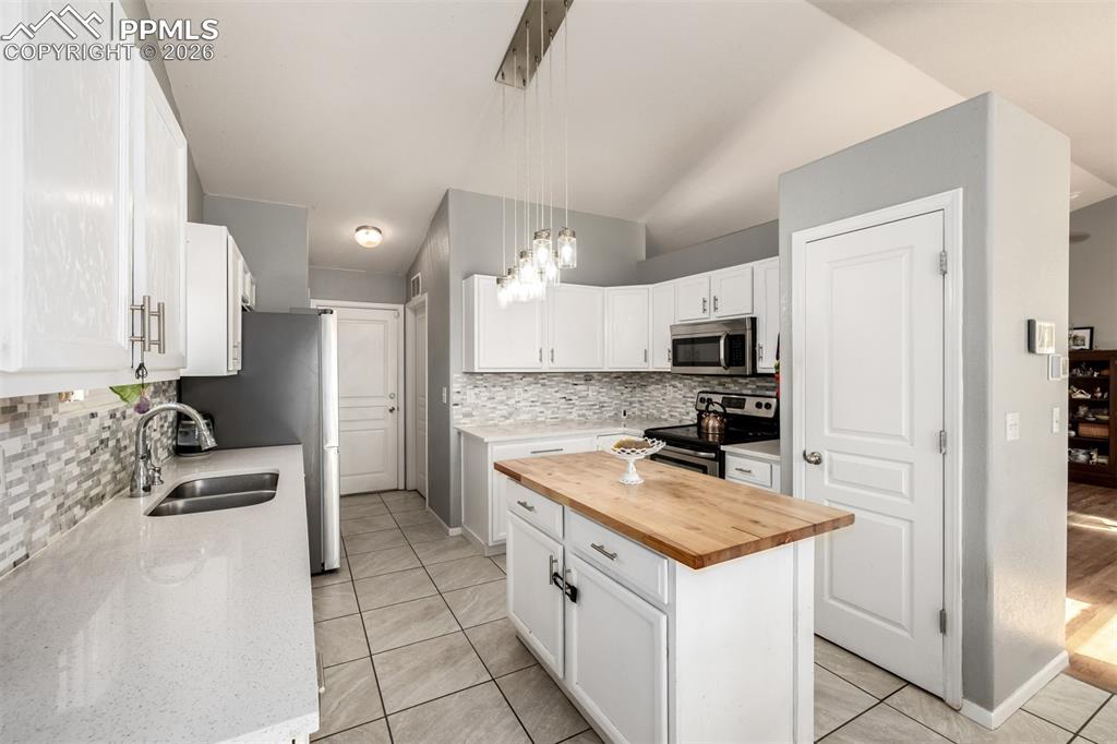 Image 10 of 37: Updated Kitchen with beautiful white cabinetry and quartz/butcher block cou
