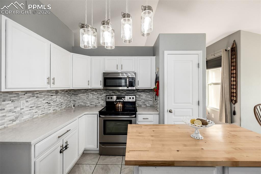 Image 11 of 37: Updated Kitchen with beautiful white cabinetry and quartz/butcher block cou