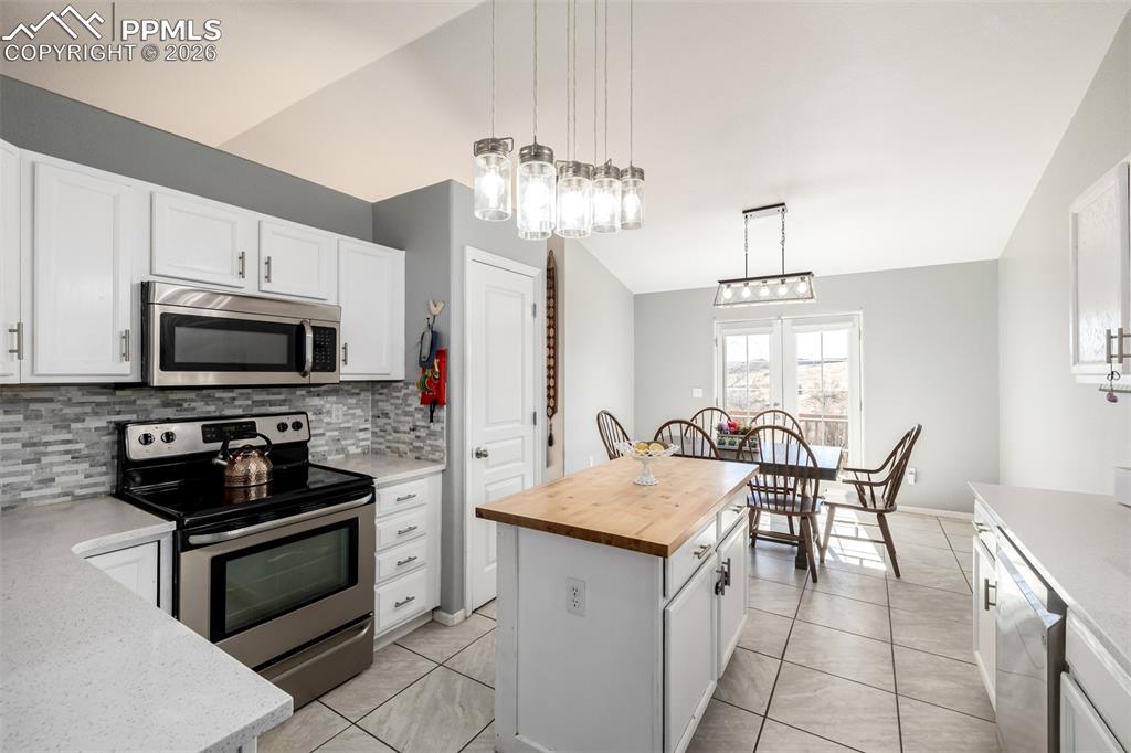 Image 12 of 37: Updated Kitchen with beautiful white cabinetry and quartz/butcher block cou