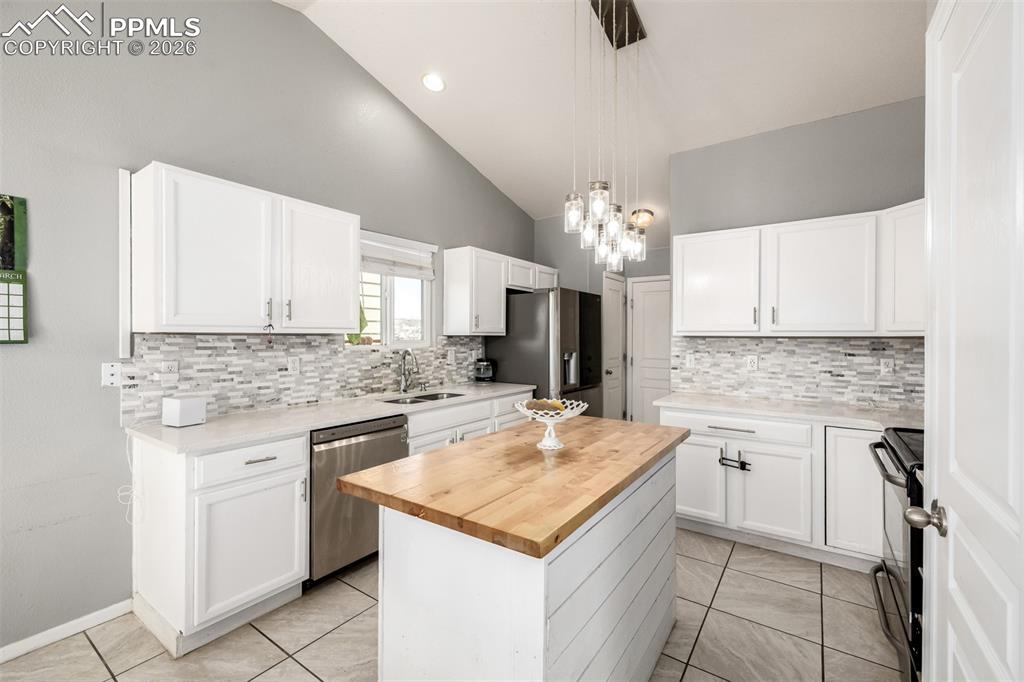 Image 8 of 37: Updated Kitchen with beautiful white cabinetry and quartz/butcher block cou