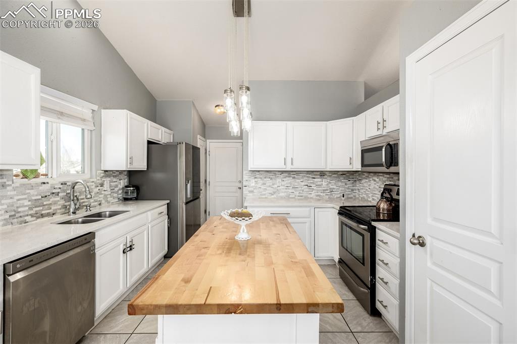 Image 9 of 37: Updated Kitchen with beautiful white cabinetry and quartz/butcher block cou