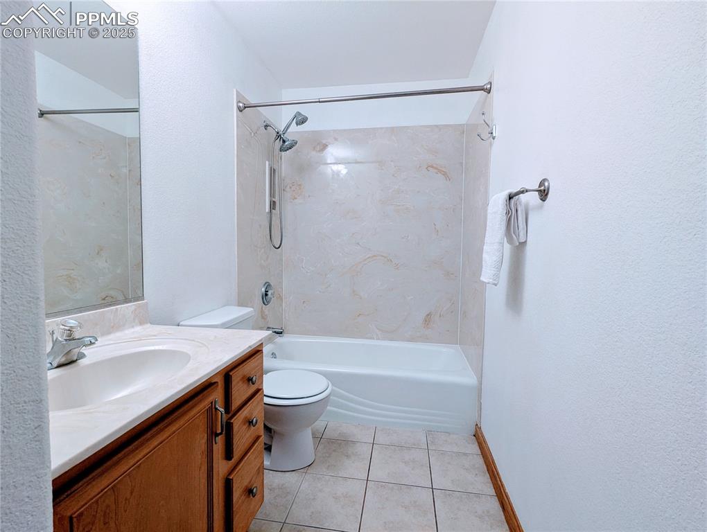 Image 12 of 19: Full bathroom featuring tile patterned flooring,  shower combination, vanit
