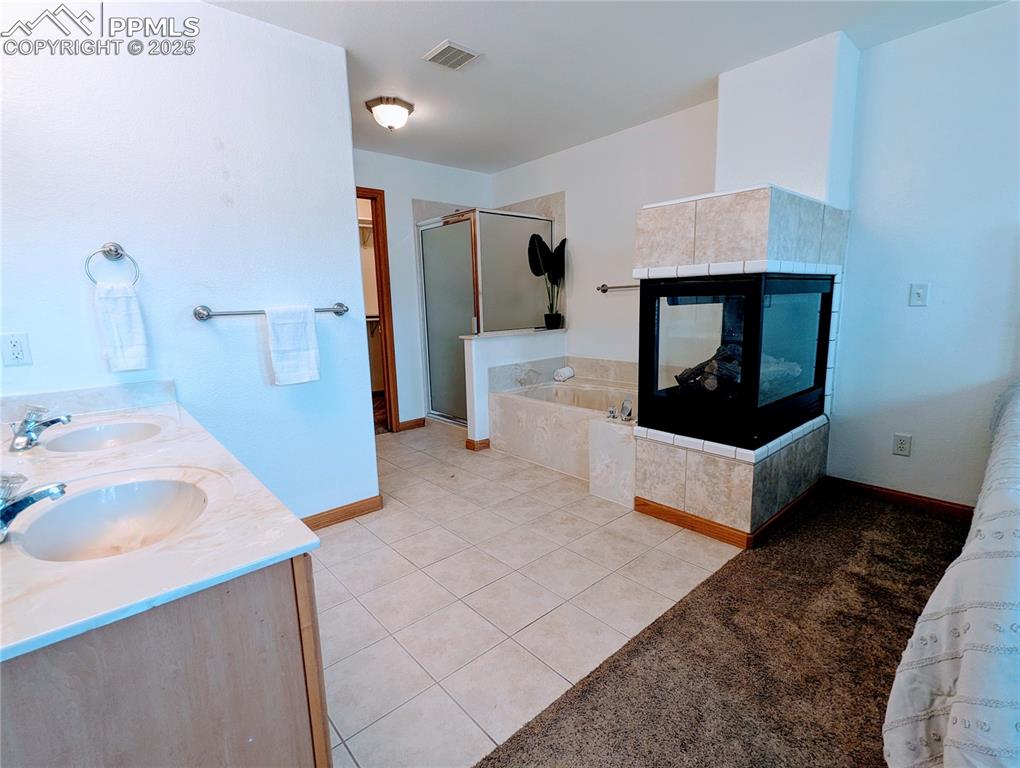 Image 15 of 19: Full bath featuring a shower stall, a garden tub, tile patterned floors, do