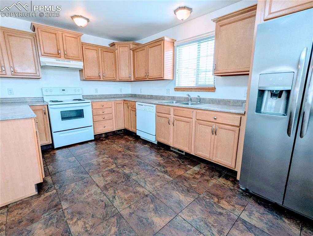 Image 5 of 19: Kitchen featuring light brown cabinetry, white appliances, under cabinet ra