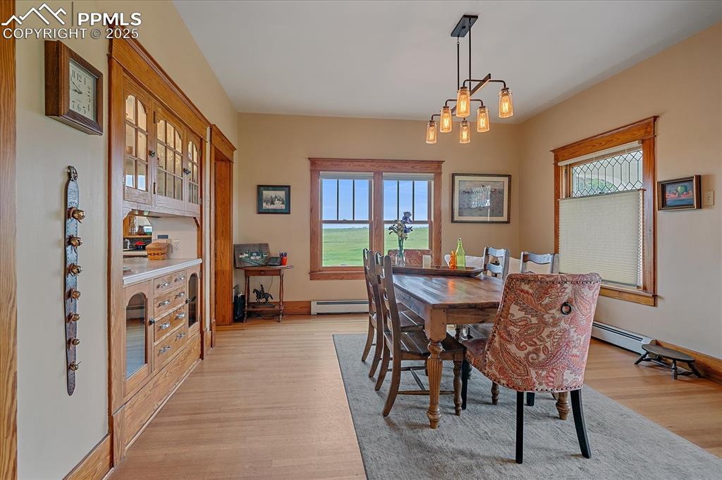 Image 10 of 44: Dining room featuring light wood finished floors, a baseboard radiator, and