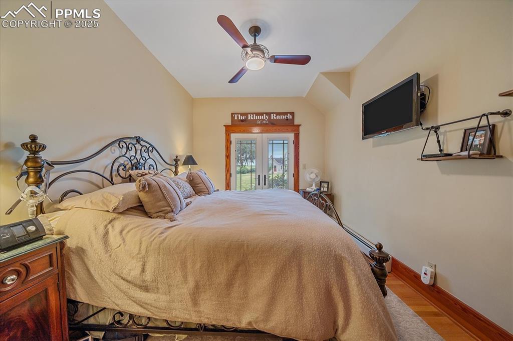 Image 15 of 44: Bedroom featuring access to exterior, wood finished floors, and ceiling fan