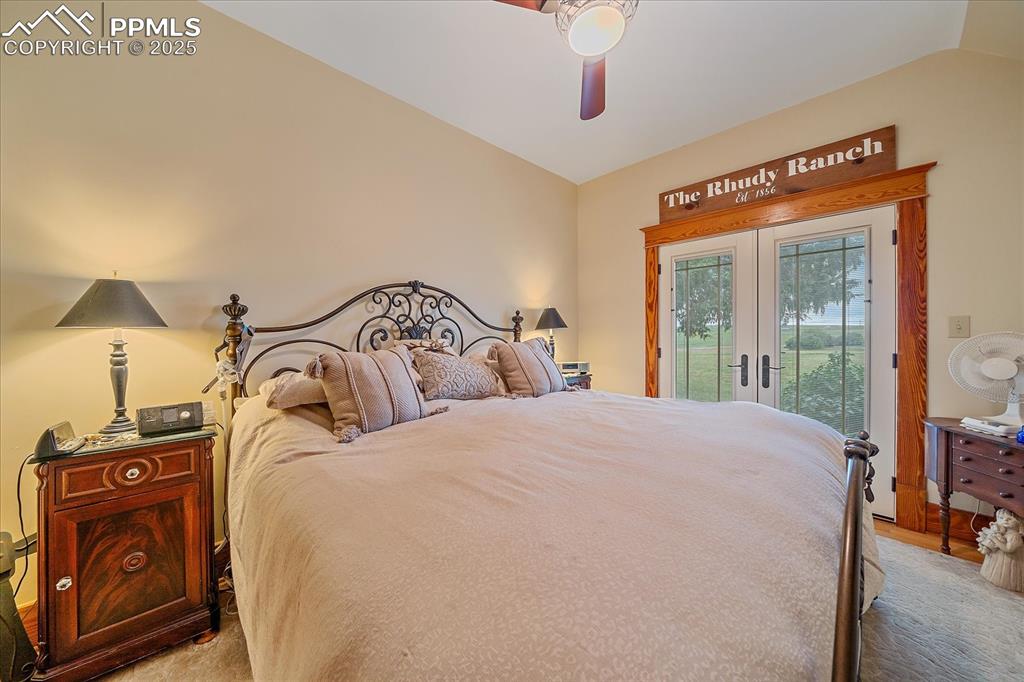 Image 16 of 44: Bedroom with french doors, access to exterior, vaulted ceiling, and a ceili
