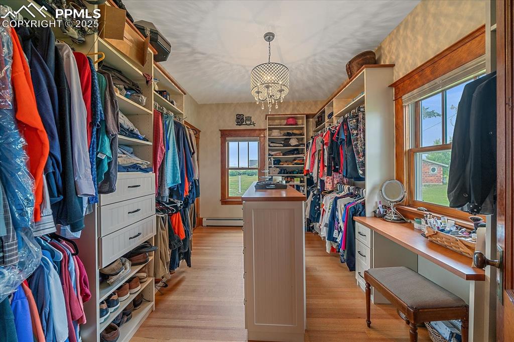 Image 17 of 44: Spacious closet featuring light wood finished floors, a chandelier, and a b