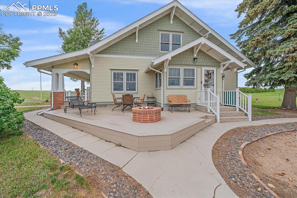Image 2 of 44: Rear view of house with a fire pit and a deck
