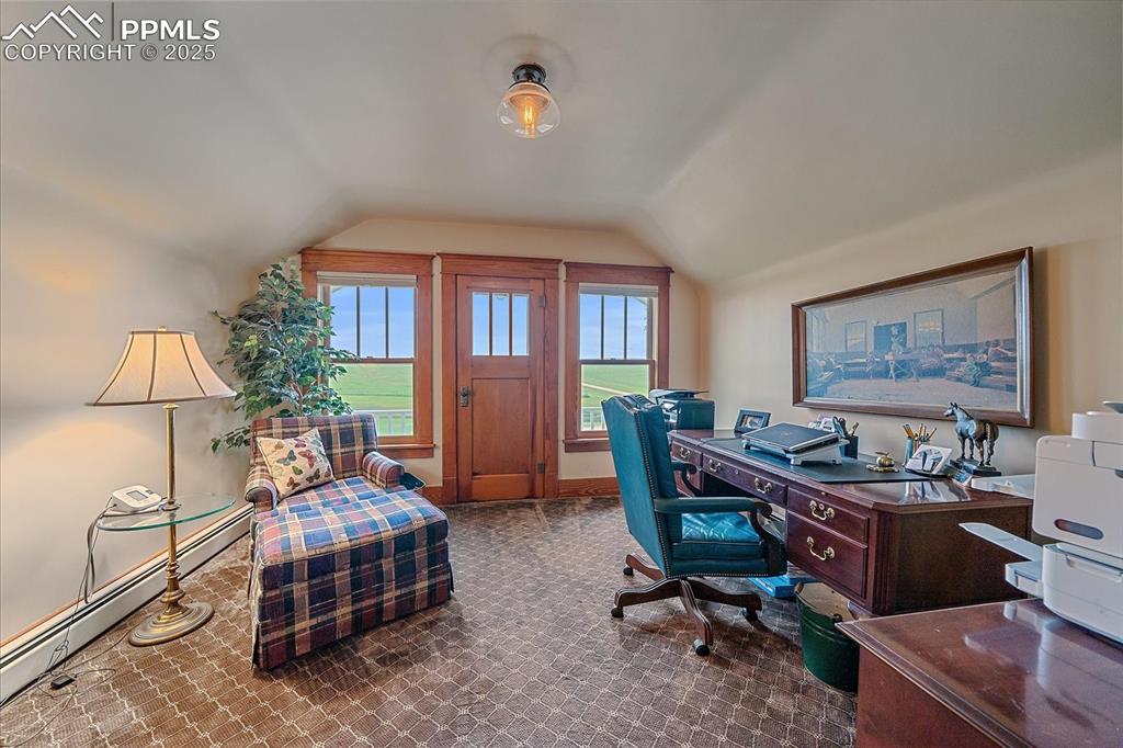 Image 22 of 44: Home office featuring lofted ceiling, baseboard heating, and carpet floors