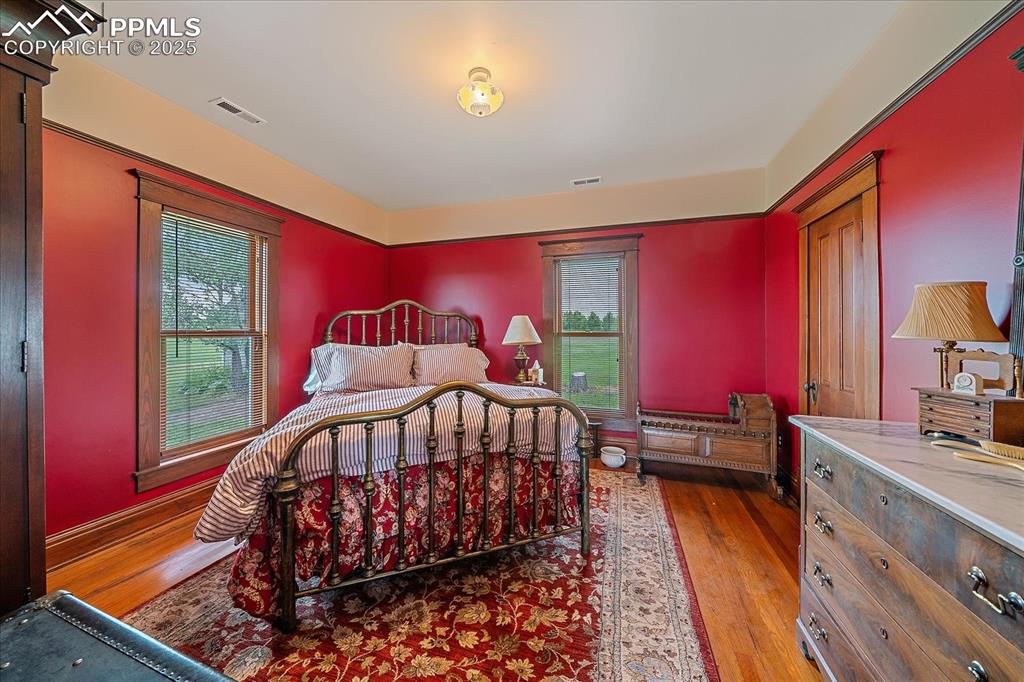 Image 28 of 44: Bedroom featuring wood finished floors and multiple windows