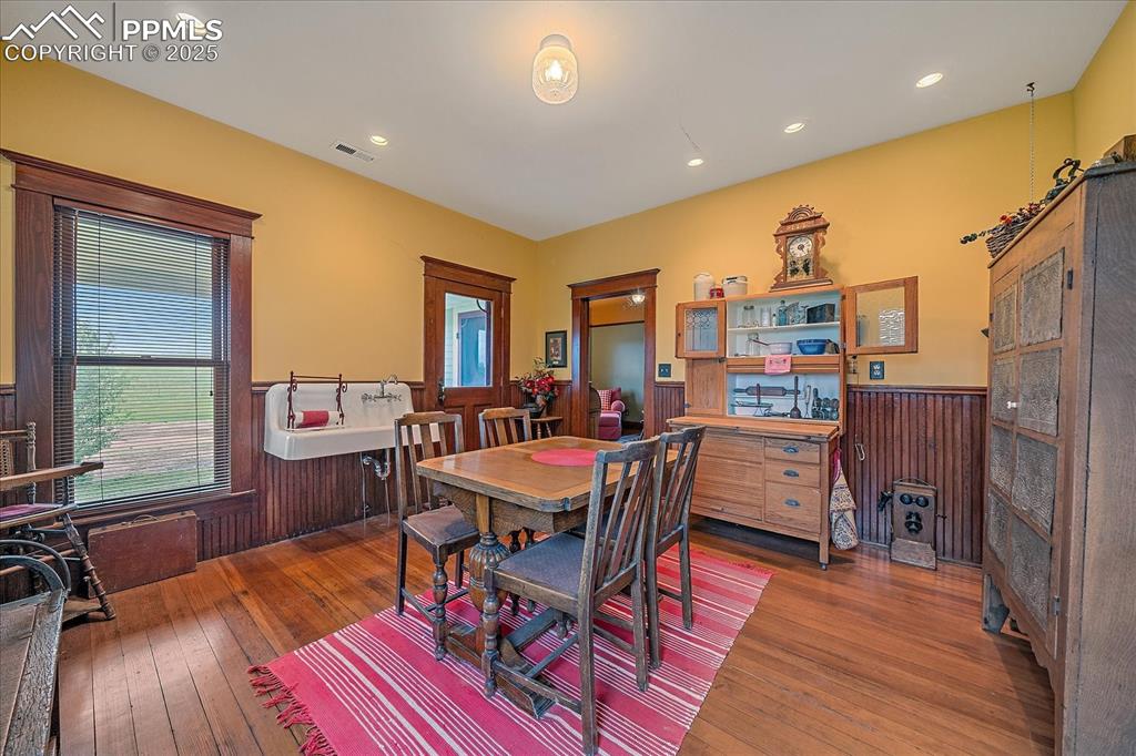 Image 34 of 44: Dining space featuring wainscoting, wood-type flooring, recessed lighting,