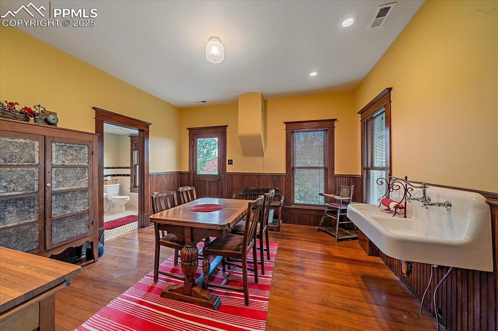 Image 35 of 44: Dining space with wainscoting, wood-type flooring, wood walls, and recessed