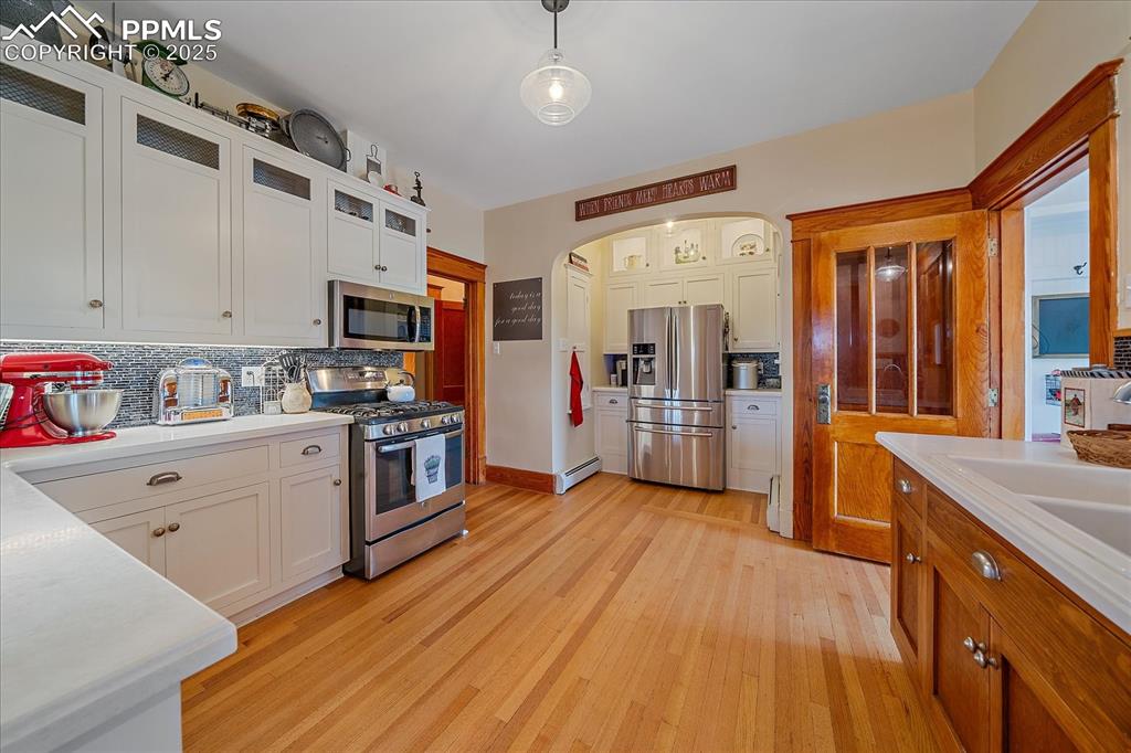 Image 8 of 44: Kitchen with appliances with stainless steel finishes, tasteful backsplash,