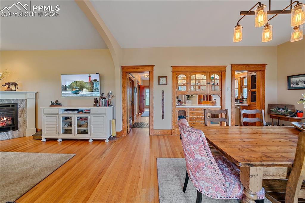 Image 9 of 44: Dining area with wood finished floors and a high end fireplace