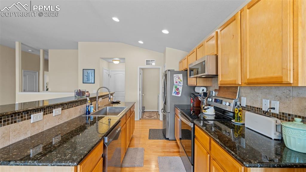 Image 12 of 28: Kitchen featuring decorative backsplash, stainless steel appliances, light 